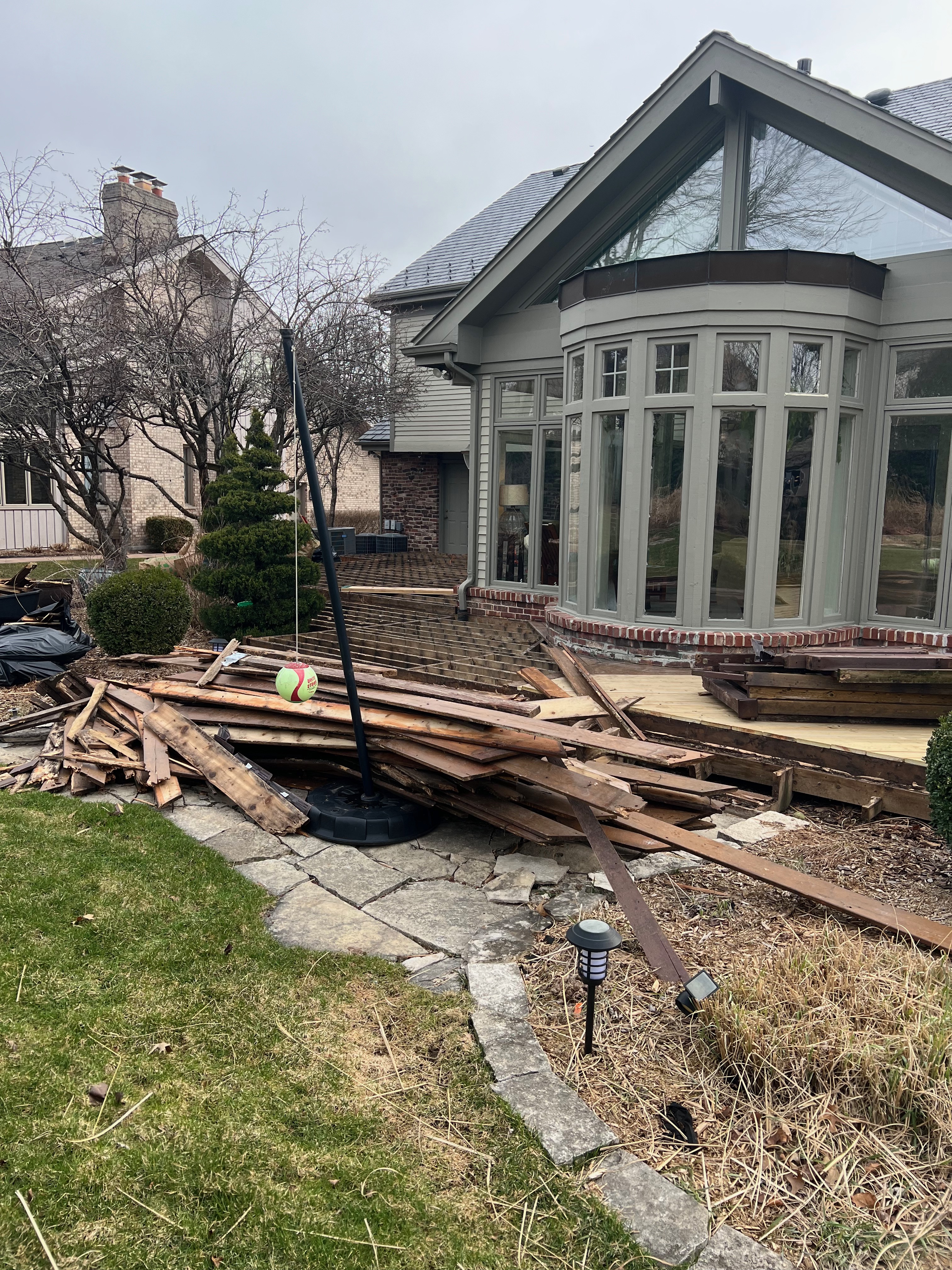 A heap of assorted discarded household items and furniture piled up on a cobblestone street, depicting a bulk waste collection day in an urban environment