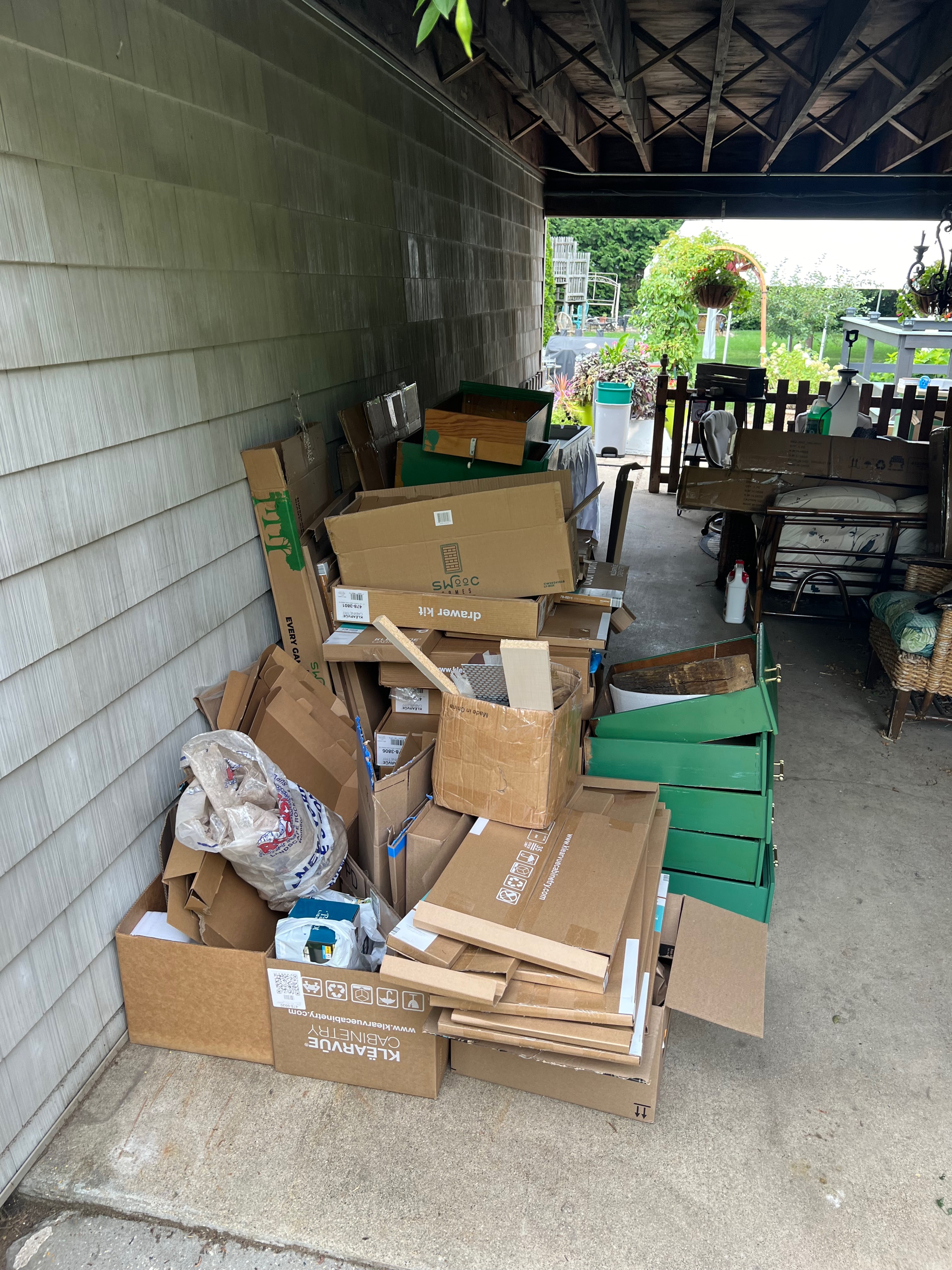 Calgary, Alberta, Canada. Jun 8, 2025. A sunlit garage stands open, revealing a clutter of household items, storage bins, hinting at a need for organization.